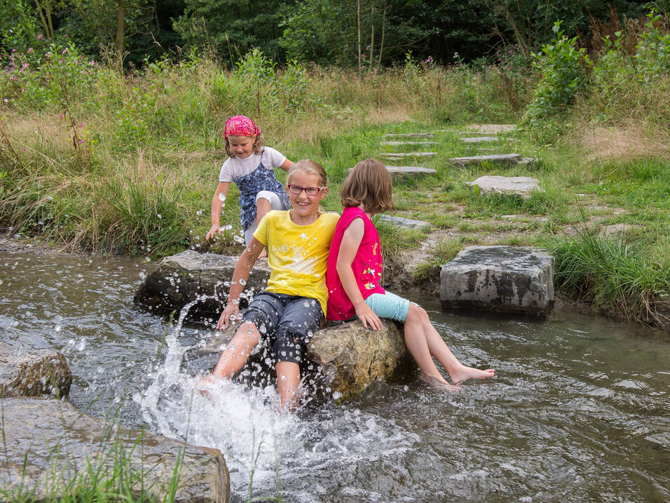 Kinderen spelen op de rivier Lenne in Fleckenberg in het Sauerland