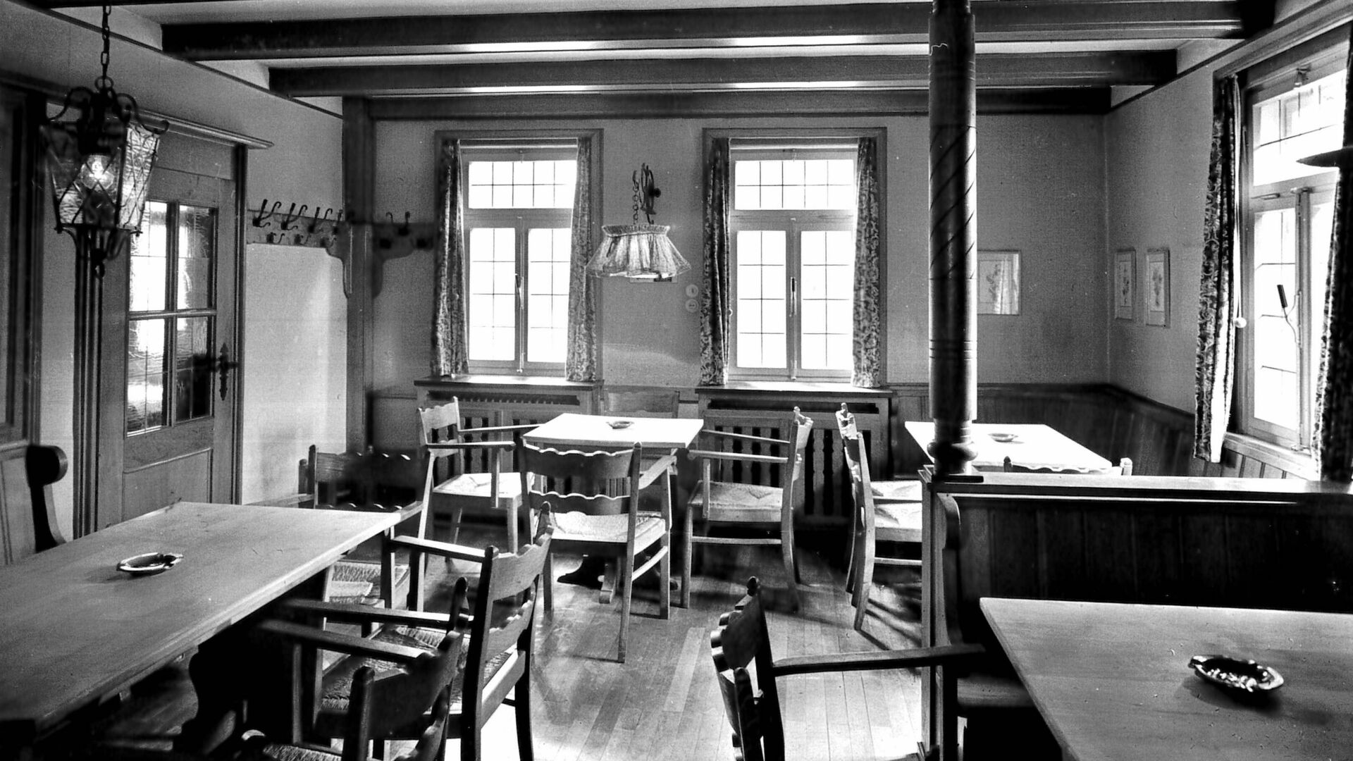 SRaum mit Fenstern, Bänken, Tischen und Stühlen, Gasthof, schwarz-weiß Fotografie